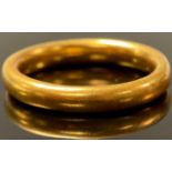 An unmarked gold wedding band, size M/N, possibly 18/22ct, 5.4g