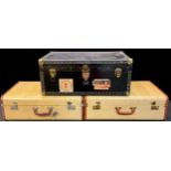 An early to mid 20th century steamer trunk, with various luggage labels including Peninsular &