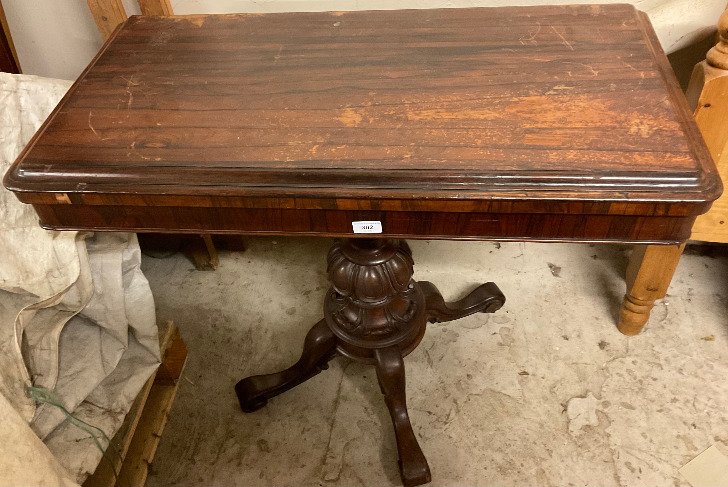 A 19th century rosewood card table, rectangular top enclosing a baize-lined playing surface, egg-