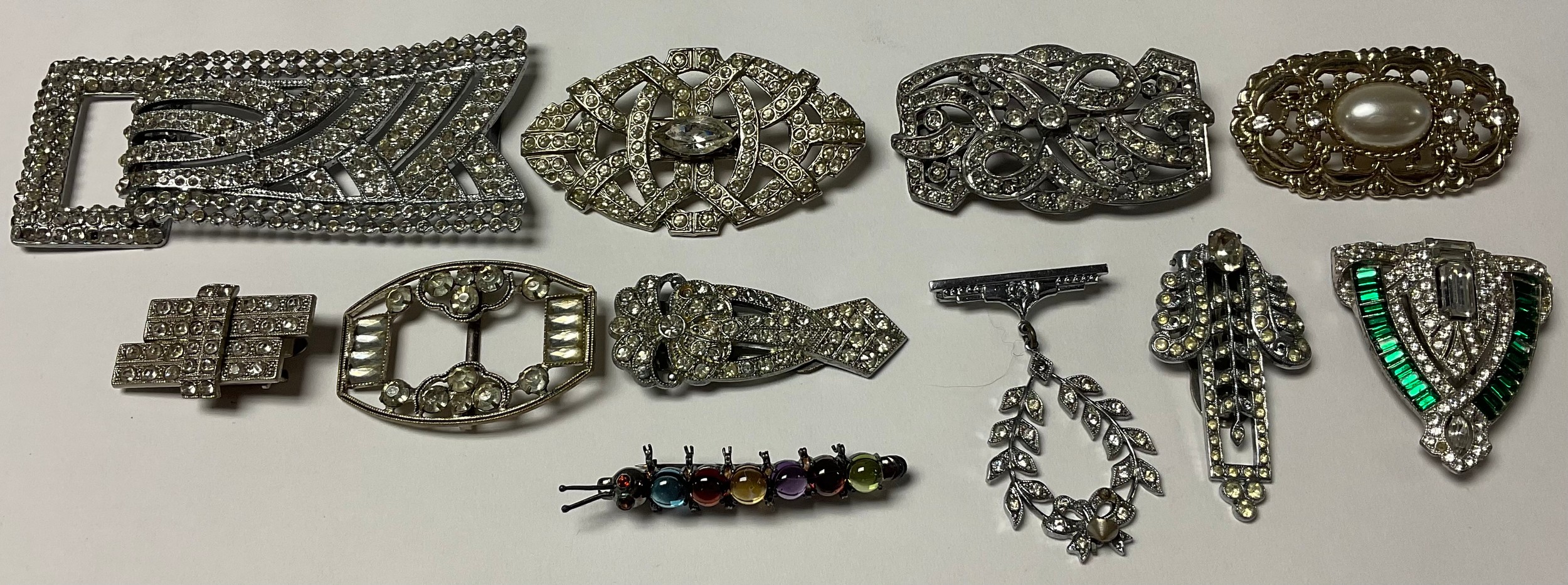 A collection of costume jewellery, brooches, belt buckles, etc