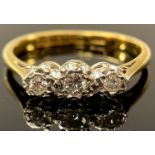 An 18ct gold three stone diamond ring, the graduated brilliant cut stones illusion set in