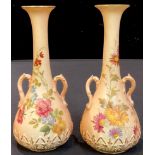 A near pair of Royal Worcester two handled slender ovoid bottle vases, decorated with flowers,