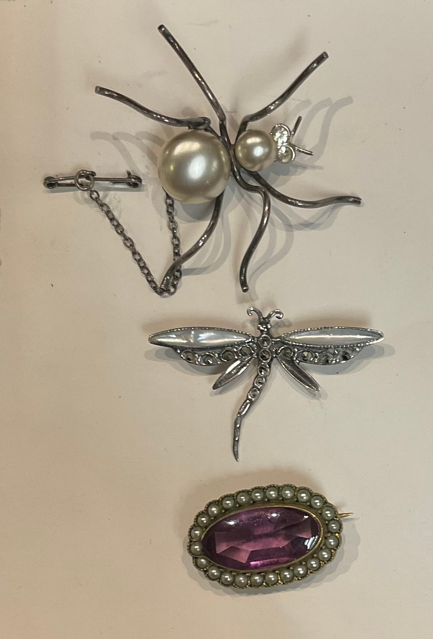 A silver and mother of pearl dragonfly brooch, marked 925; a silver spider brooch, unmarked; a pearl