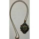 A 19th century oval mourning pendant/brooch, cast with leafy turquoise set flowerheads, to verso