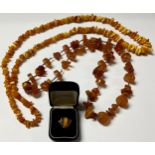 A silver and amber ring; an amber chip necklace; another amber type decorative necklace (3)