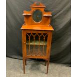 An Edwardian inlaid mahogany music cabinet, shaped mirrored back above ebony and satinwood inlaid