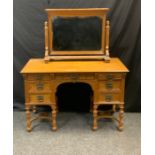 An early 20th century Gillows oak mirror back dressing table, rectangular oversailing top, three