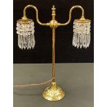 A late 19th/early 20th century style brass table lamp, two arm arched lights each with cut glass