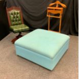 A revolving green leatherette desk chair; turquoise upholstered foot pouffe; contemporary dressing