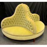 A large Victorian style conversation seat, the circular four sided button back body upholstered in