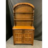 Priory style dresser of small proportions, plate rack back over cupboard with two freize drawers and