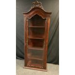 A victorian style arch topped vitrine/display cabinet carved floarl crest above single glazed door