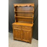 A prior oak dresser, two tier plate rack back above two drawers and two linen fold doors, 178cm