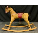 A mid 20th century Rocking Horse, fabric body, leather saddle, seat 59.5cm high, wooden rocket