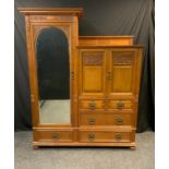 An early 20th century Gillows oak linen press wardrobe, tall section with carved pelmet, hanging