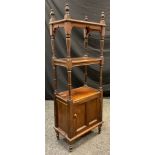 An early 20th century walnut and oak what-not, turned finials and supports, three tiers of