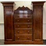 A Victorian mahogany compactum wardrobe, chest centre with five long graduated drawers, flanked by a