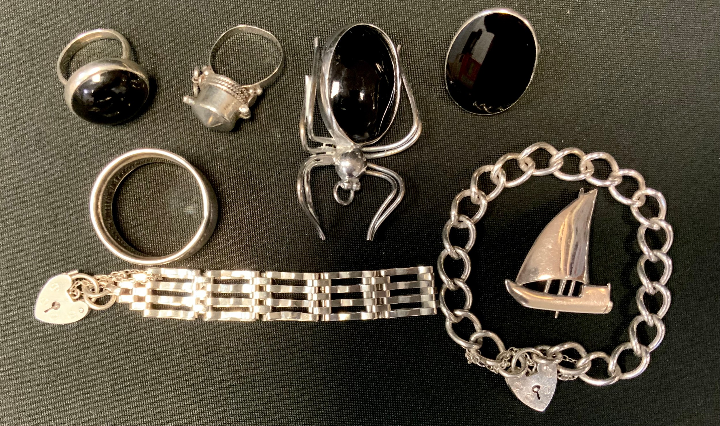A silver four bar padlock bracelet; another; spider 'onyx' type brooch; dress rings; a silver