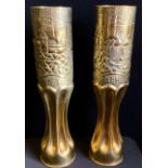 A pair of World War I trench art shell case vases, hand embossed with Castle landscape panels,