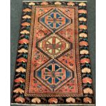 A central Persian Bakhtiar rug / carpet, knotted in tones of pale red, blue, cream, and deep blue,