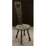 A Victorian Welsh carved oak spinning chair, owl heart scroll back, octagonal seat board, turned