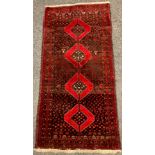 An East Persian Balouch or Baluch rug / carpet, hand-knotted in deep red and black with a central