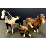 A Beswick model Pinto pony, piebald, No 1373, gloss; others Mountain pony and foal, brown gloss, (3)