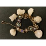 An enamelled white metal and carved stone bead bracelet, the floral link panels suspending six