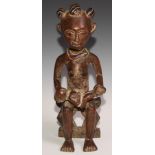 An Ashanti Acan tribal fertility figure, seated mother cradling her child, beaded neck 45cm high