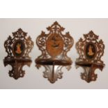 A garniture of three Italian olivewood and marquetry folding wall brackets, each pierced and