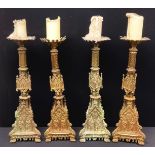 A set of four Gothic Revival gilt metal altar pricket candlesticks, cast throughout with figures and