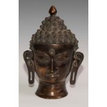 An Asian bronze mask or plaque, the head of a bodhisattva, 30cm long