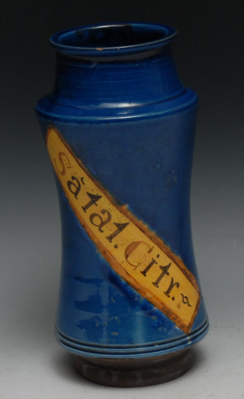 A Continental albarello drug jar, inscribed Dacty Li, within a yellow banner on a blue glazed