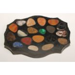 A pietra dura shaped serpentine desk weight, inlaid with pebble shaped reserves of malachite, laps