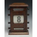 An early 20th century oak perpetual calendar, sarcophagus cresting above glazed apertures for day,