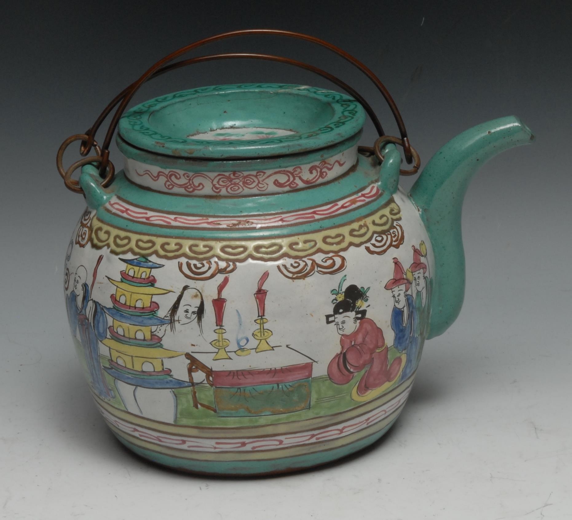 A Chinese Yixing type wine pot, brightly decorated in polychrome enamels with figures, 21cm long