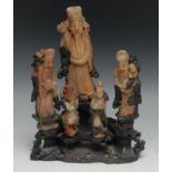 A Chinese soapstone figure group, comprising five carved Immortals on an openwork rocky outcrop,
