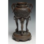 A Chinese bronze incense burner, cast in relief with shaped reserves of lotus and branches,