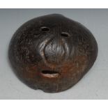 Tribal Art - a coconut shell mask, abstract features, pierced eyes and mouth, 13.5cm wide,