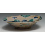 A Middle Eastern tin glazed bowl, decorated in the Islamic Persian manner with stylised organic