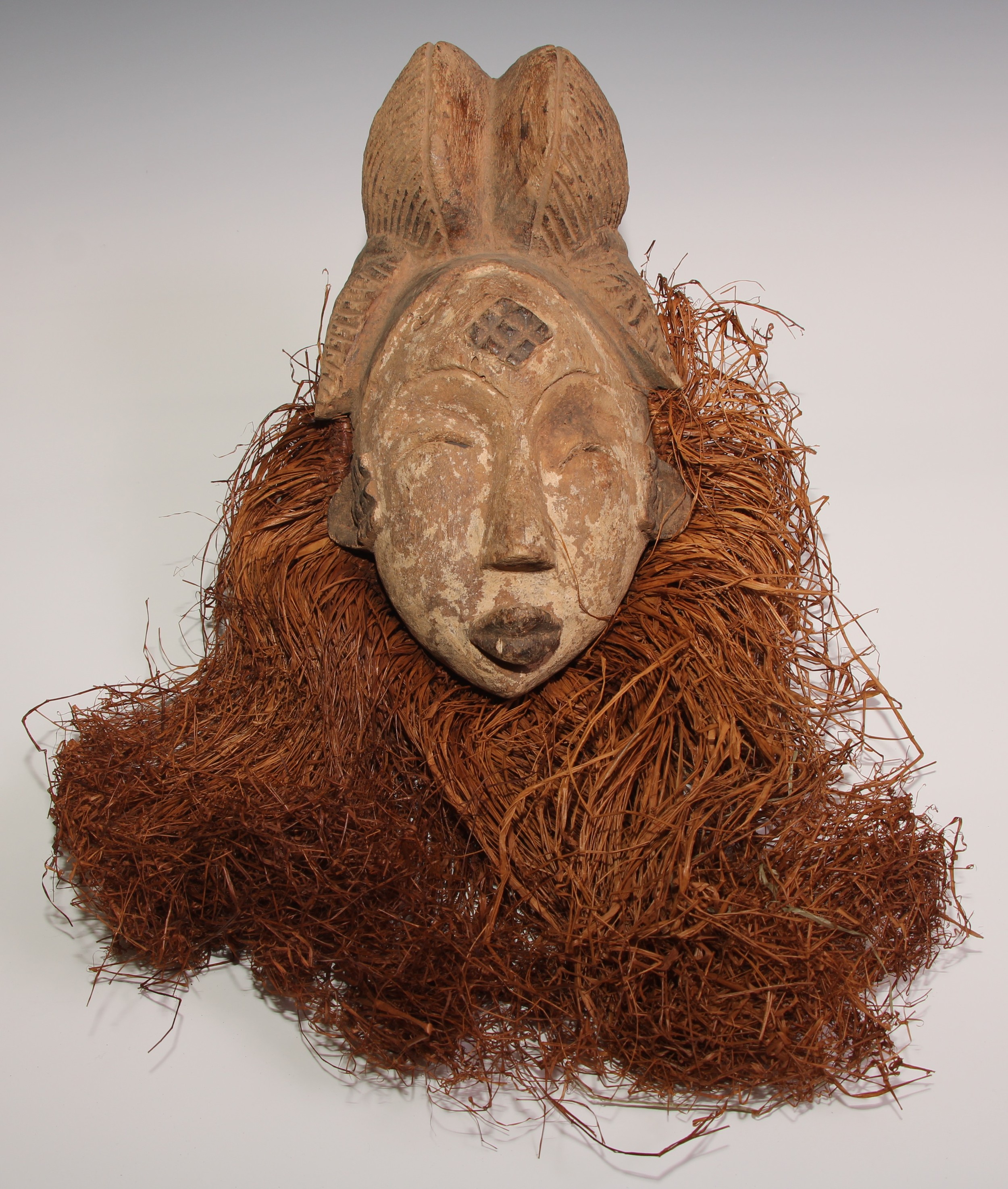 Decorative Tribal Art and the Eclectic Interior - a Baule mask, elaborate stylised coiffure,