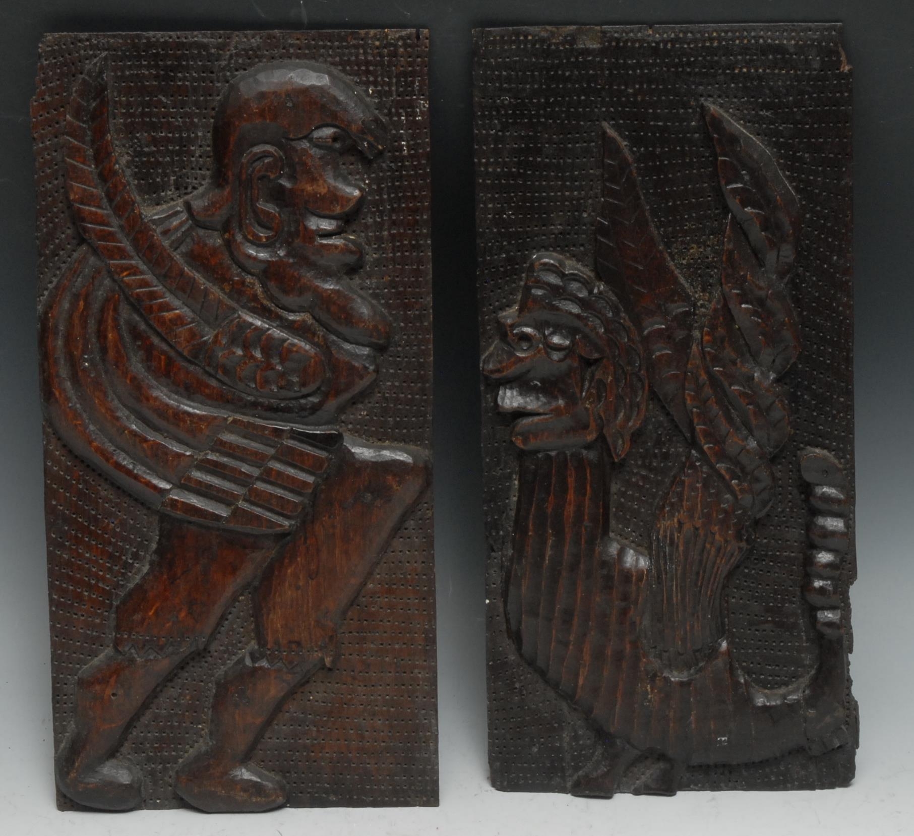 A pair of 18th century oak panels, each carved with a mythical beast, 30.5cm x 15cm (2)