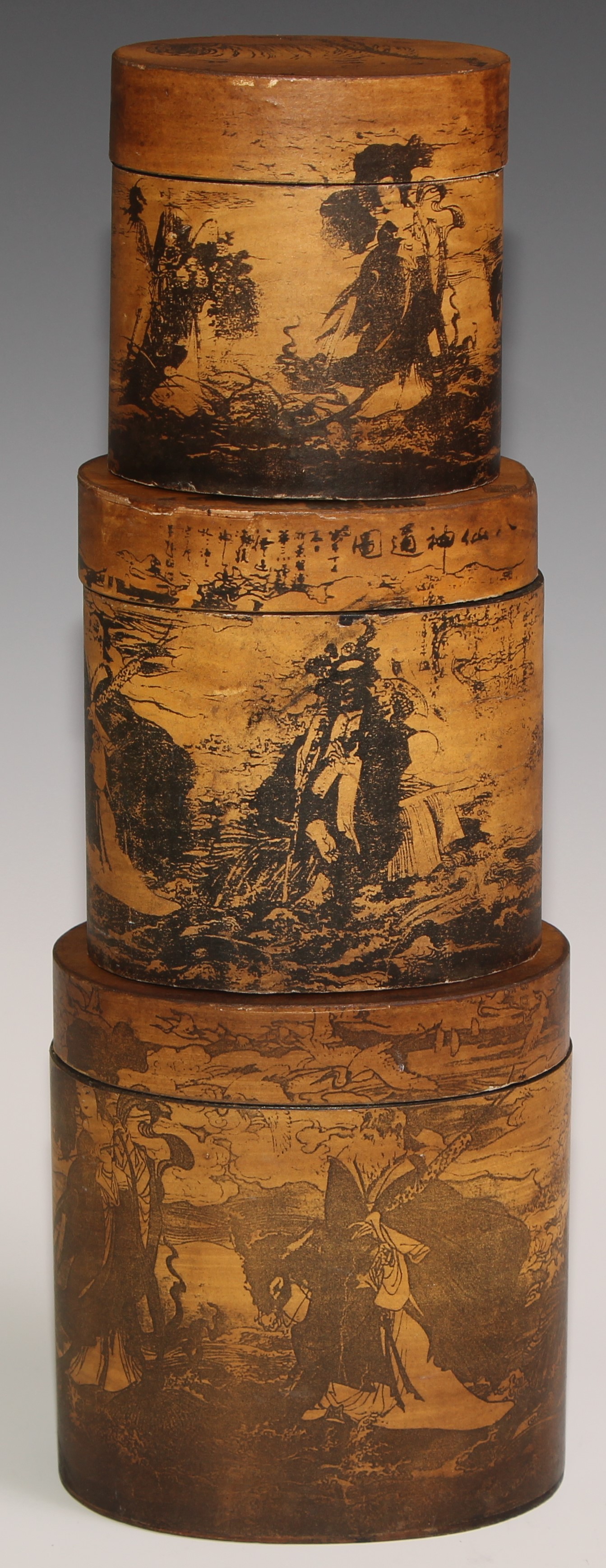 A stacking nest of Japanese oval boxes, decorated with bears and narratuve scenes, the largest 13.