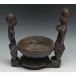 Tribal Art - an African offering bowl, flanked by a pair of opposing figures, 23.5cm wide,