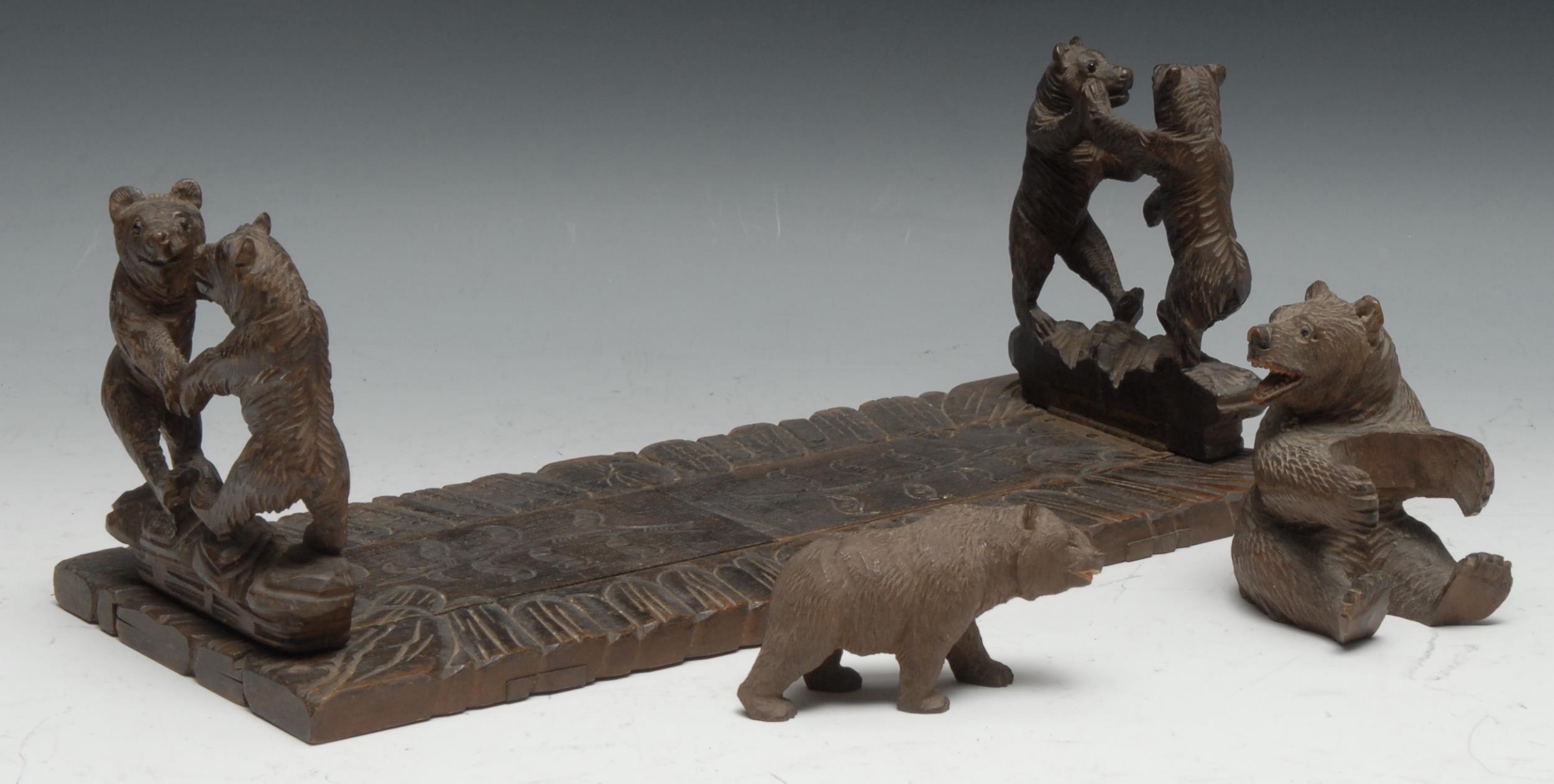 A Black Forest carved wooden book slide, the ends carved with two fighting bears, 34cm closed, c.