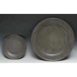 An 18th century pewter circular charger, 38cm diam, c.1760; a plate, 22.5cm diam, indistinct touch