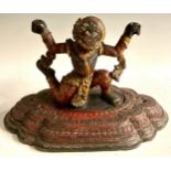 A South Asian polychrome carving, of a demon, stepped lotus base, 46cm wide, 19th/early 20th century