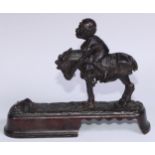 A 19th century American cast iron novelty mechanical bank money box, as a jockey thrown from his