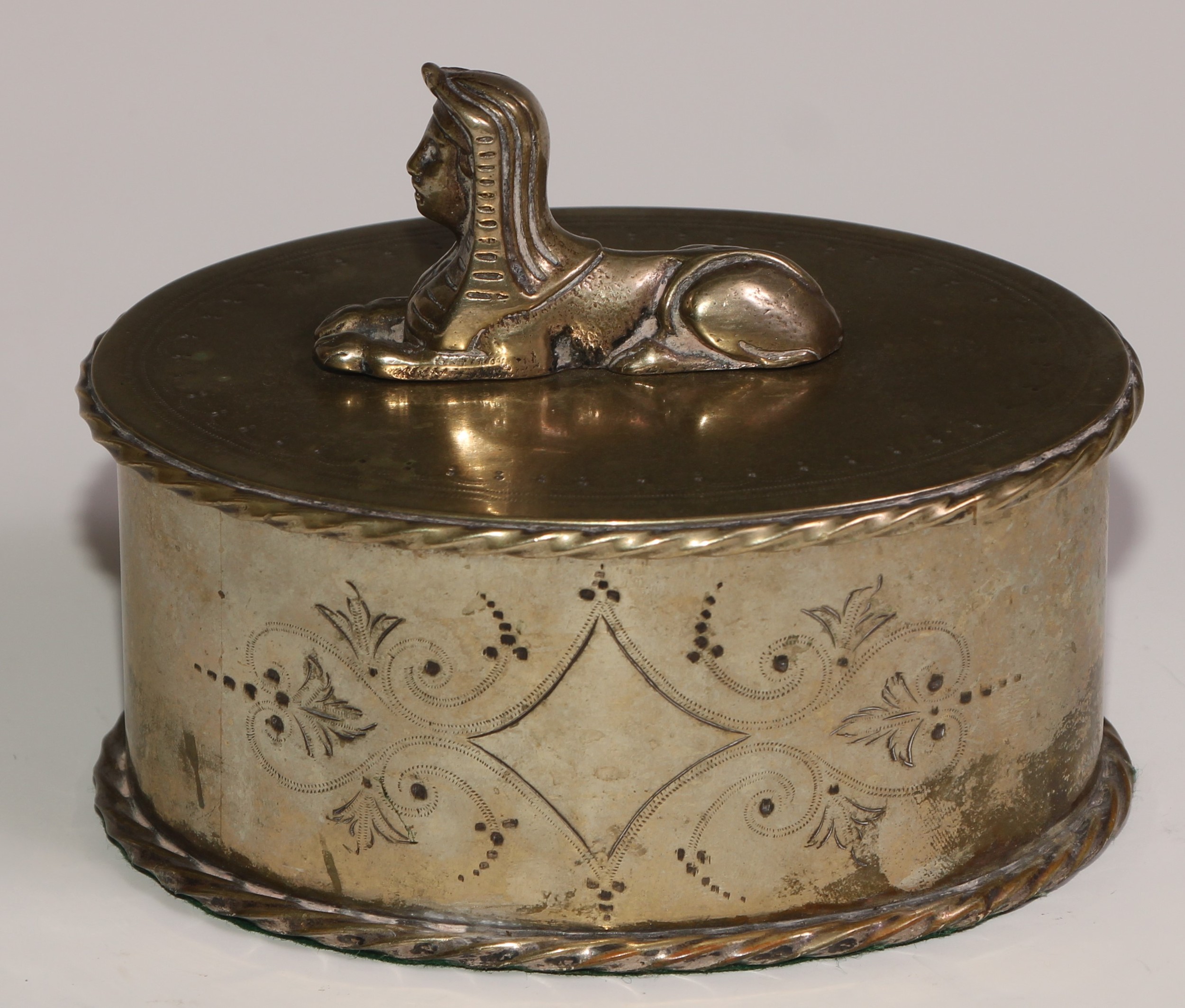 A Victorian Egyptian Revival silver plated oval box and cover, bright-cut engraved and surmounted by