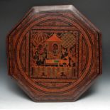 A 20th century octagonal lacquered table top, decorated with deities, and feathered bands, 61cm wide